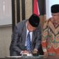 Ketua PWM Sumbar, Bakhtiar saat menandatangani serah terima BPH UM Sumbar periode 2023-2027. (Dok.Humas PWM Sumbar)