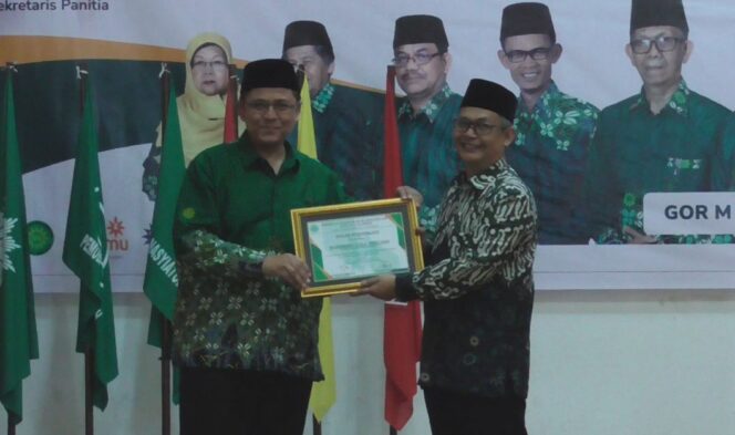   Ketua PDM Kota Payakumbuh, Irwandi Nashir (kiri) menyerahkan piagam penghargaan kepada Sekretaris PP Muhammadiyah, Muhammad Izzul Muslimin usai menyampaikan ceramah pecerahan, Minggu (18/6/2023) di Payakumbuh. (Dok. PDM Payakumbuh).