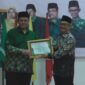 Ketua PDM Kota Payakumbuh, Irwandi Nashir (kiri) menyerahkan piagam penghargaan kepada Sekretaris PP Muhammadiyah, Muhammad Izzul Muslimin usai menyampaikan ceramah pecerahan, Minggu (18/6/2023) di Payakumbuh. (Dok. PDM Payakumbuh).