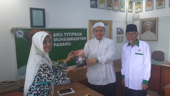 
 dr.Hj.Maisarah (kiri) memberikan buku karyanya 